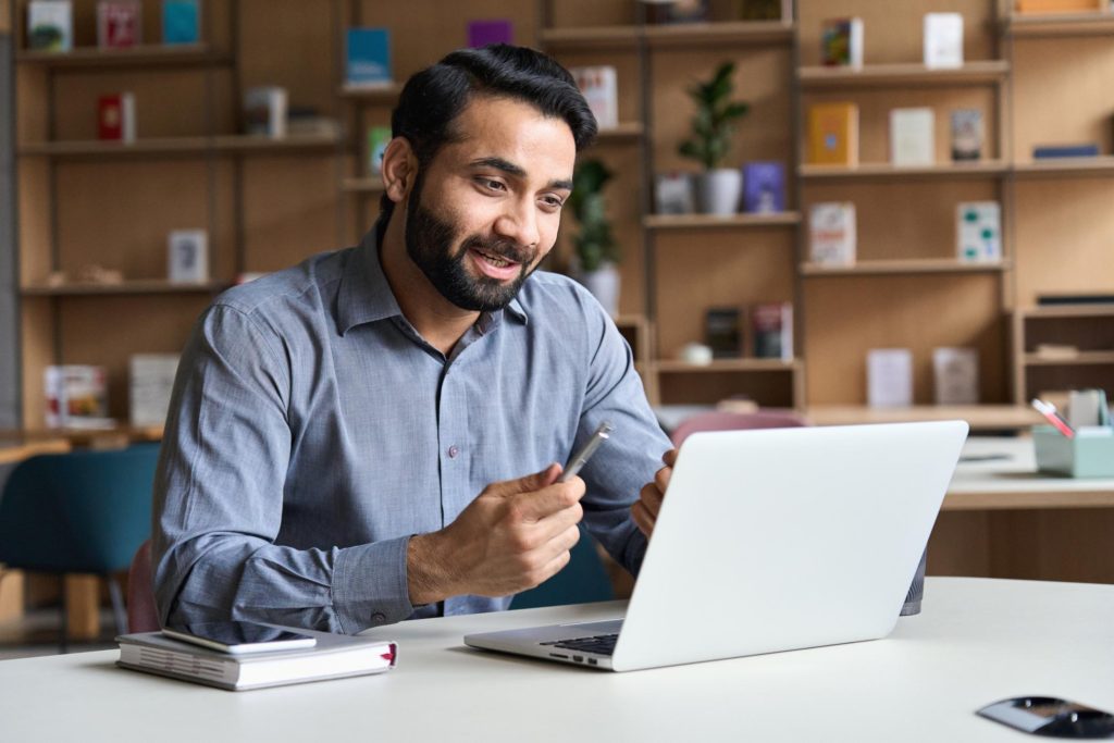 Happy man looking at laptop computer in office